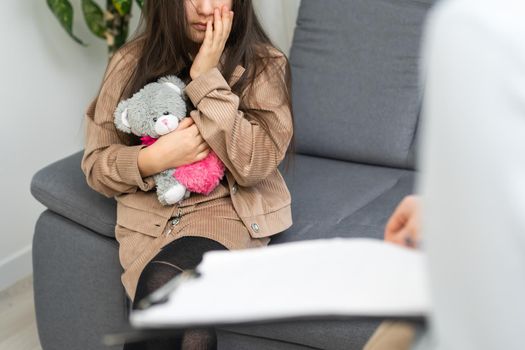 Female psychologist working with little girl at home.