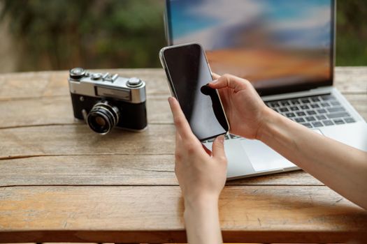 Close up of lady typing on smartphone while working online outdoors