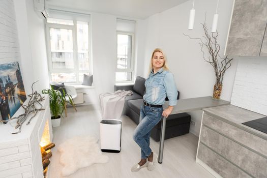 Woman In Living Room Using Air Cleaner And Humidifier.