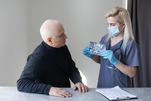 Dental Clinic. An elderly retired gentleman, discussing with his dentist radiography (x-ray) results