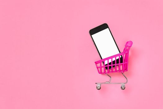 E store online supermarket cart with phone mockup mobile shopping cart isolated on pink background. Digital shopping pink concept sales mobile online shopping trolley isolated screen smartphone mockup