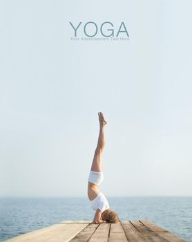 Beautiful positiveblond girl practicing yoga at seashore and meditating