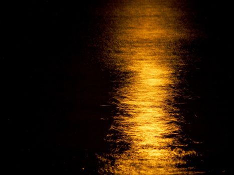 Orange Moon Light Reflects on the ocean.