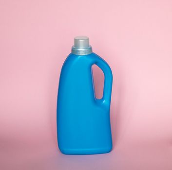 Blue plastic bottle with a grey cap isolated on pink background for liquid detergent laundry or cleaning agent. Packaging template mockup