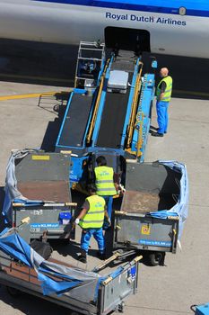 Amsterdam The Netherlands -  May 26th 2017: KLM Boeing 737 parked at gate at Schiphol International Airport, luggage handling