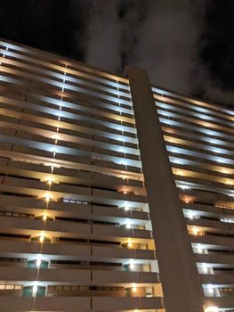 Honolulu - October 24, 2018: Looking up a Condo Building with outdoor hallway at Night.