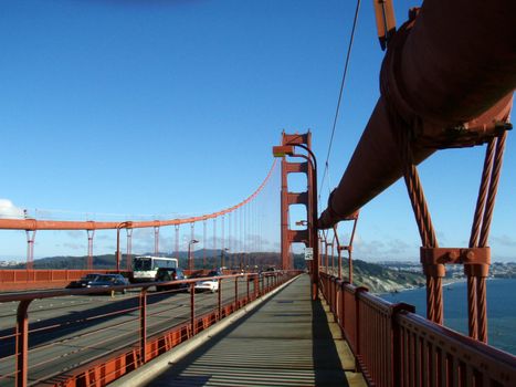 Art Deco Walkway and road on the Golden Gate Bridge with tower in the distance on a nice day.