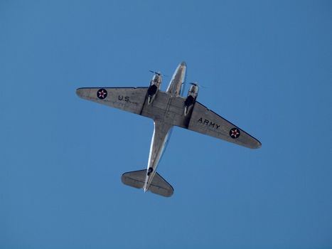 US Army Propeller plane flies overhead against a blue sky in USA.