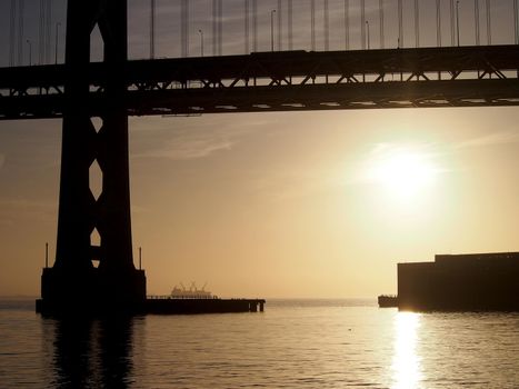 Sunrise over San Francisco Bay and the Bay Bridge with boats in the water and awesome clouds in the sky in California.  November 14, 2011.