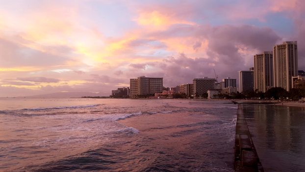 Dusk at world famous tourist area Waikiki on a beautiful day with hotels in the distance. 