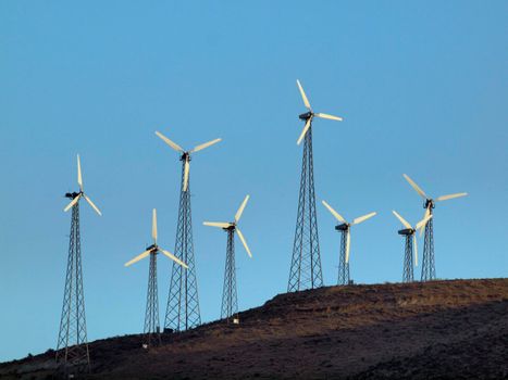 Modern Windmills spin on hillside on California.