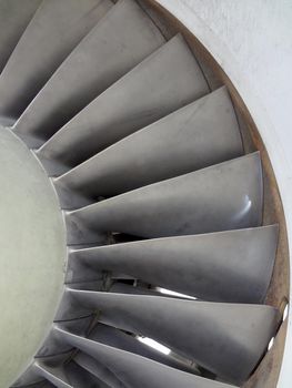 Close up of turbine and fan blades of a fighter jet engine with signs of wear.