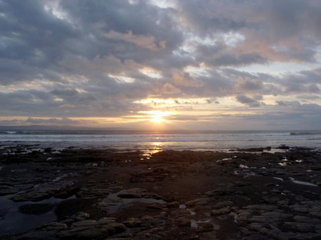 Sunset in clouds over the ocean on Rocky beach of Punta Banco, Costa Rica.