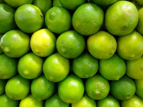Limes stacked on top of each other on display in market.