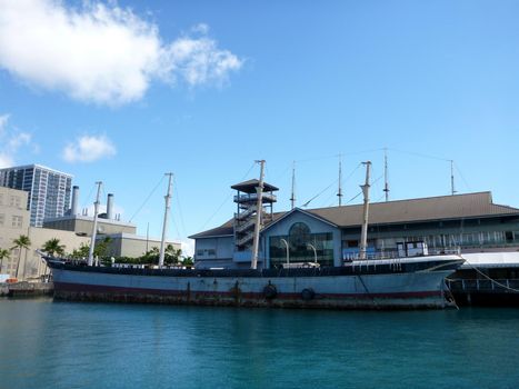 Historic Falls of Clyde Ship sits in Honolulu Harbor at dusk. Falls of Clyde is the last surviving iron-hulled, four-masted full rigged ship, and the only remaining sail-driven oil tanker. Designated a U.S. National Historic Landmark in 1989.