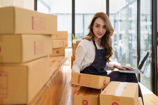 Young Asian woman at warehouse to delivery to Entrepreneur owner SME. Business digital online SME small business and online shop