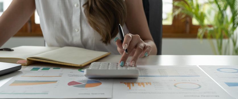 Woman doing finance and calculate on desk about cost at home office