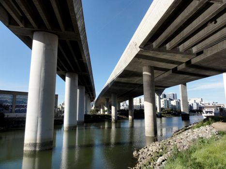 Overhead Highways on columns in the air as they go into the city of San Francisco as they hang over Mission Creek on a nice day in California. 