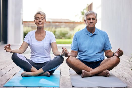 Channel your place of calm. a mature couple meditating together outdoors