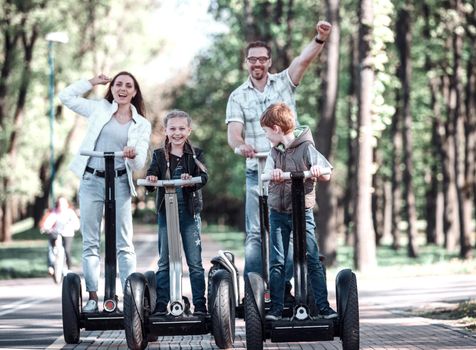 modern family riding an electric mini hoverboard in the Park. We go together.