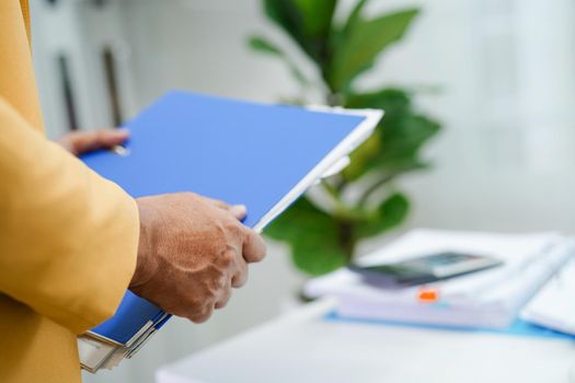 Businessman working and prepare paperwork report data to analysis information in file binder at office.