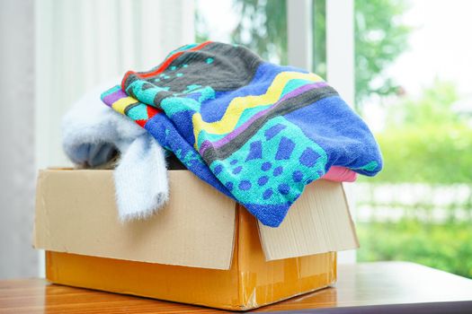 Clothes donations in cardboard box for volunteer.