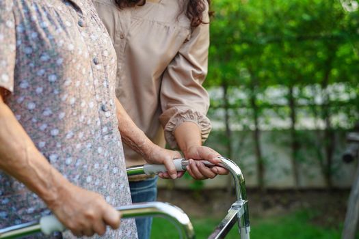 Caregiver help Asian elderly woman disability patient in nursing hospital, medical concept.