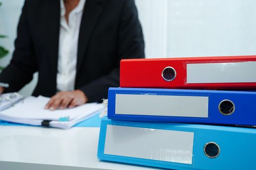 Stack of binder file folder on table in business modern office.
on wooden desk in large modern office 
