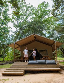 Budget Safari tent in South Africa for family vacations in nature, Safari tented camp in green forest bush nature. Asian women and European men camping