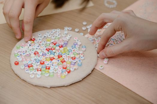 Jewelry making and beading process.The process of making jewelry.A woman makes jewelry in a workshop.Fashion, creativity and handmade concept