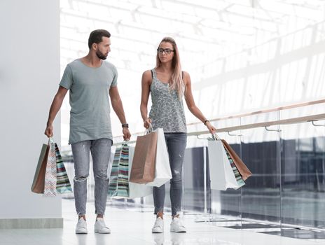 husband and wife with shopping bags go together .photo with copy space