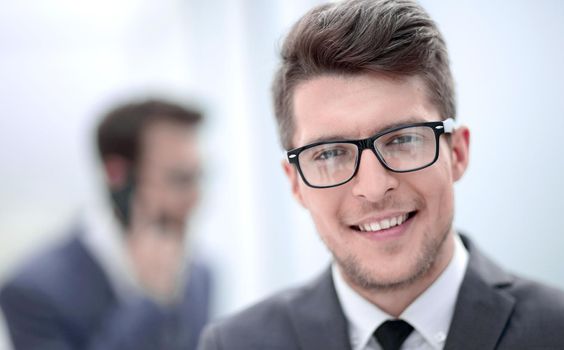 close up.smiling young businessman in the office background.photo with copy space