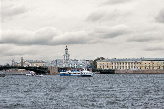 Saint-Petersburg, Russia. - July 27, 2002 View of the city across the waters of the Neva River with recreational water transport on a cloudy rainy summer evening. Selective focus.