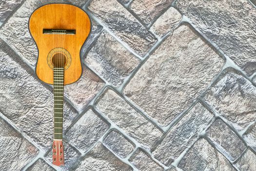 a brief record of facts, topics, or thoughts, written down as an aid to memory. a stringed musical instrument, with a fretted fingerboard. acoustic guitar on gray brick wall.