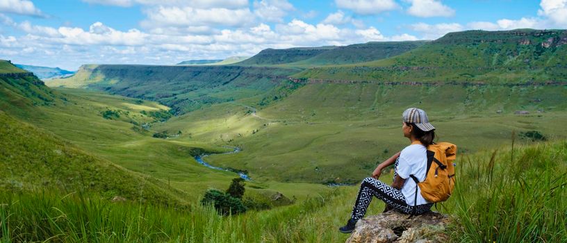 Young woman hiking in the mountains, .Drakensberg Giant Castle South Africa,Drakensberg mountain ,Central Drakensberg Kwazulu Natal, green mountains in South Africa, young Asian woman hiking