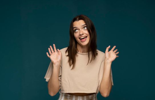 Attractive excited young girl wearing casual clothing standing isolated over blue background