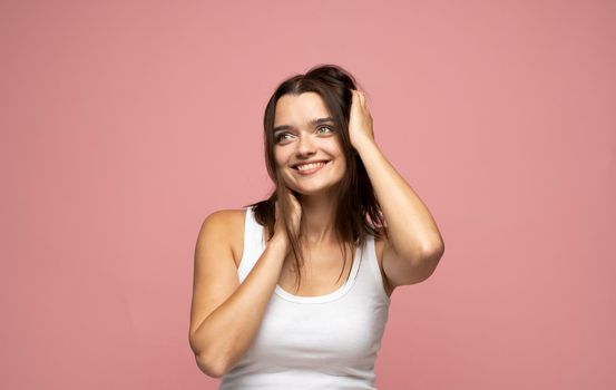 Attractive brunette woman with long hair being very glad smiling with broad smile showing her teeth and having fun indoors. Joyful excited cheery female