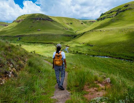 Young woman hiking in the mountains, .Drakensberg Giant Castle South Africa,Drakensberg mountain ,Central Drakensberg Kwazulu Natal, green mountains in South Africa, young Asian woman hiking