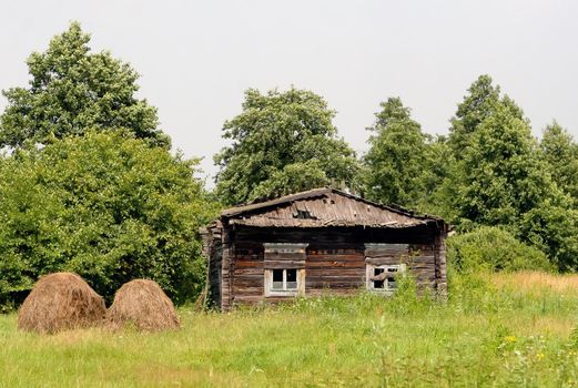 Abandoned house in disrepair in a field in the countryside.
