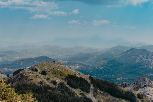 Panoramic view of idyllic mountain scenery in the Alps with fresh green meadows in bloom on a beautiful sunny day. Summer mountain landscape Landcscape hight mountains. Landscape in the fields.