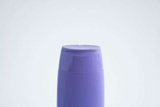 Violet plastic bottle of body care and beauty products. Studio photography of plastic bottle for shampoo, shower gel, creme isolated on white background