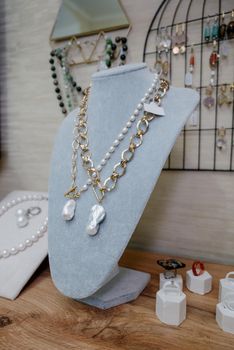 Shop window with necklaces and jewelry. Custome jewelry on display.Variety of colorful necklaces, bracelets, earrings, rings in window of costume jewelry store