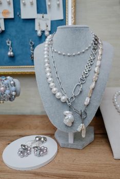 Shop window with necklaces and jewelry. Custome jewelry on display.Variety of colorful necklaces, bracelets, earrings, rings in window of costume jewelry store