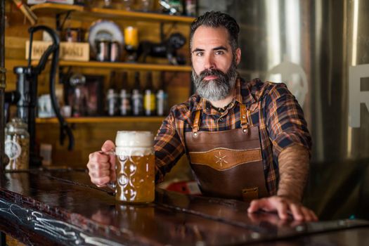 Portrait of barmen with beer glass full of beer at pub.