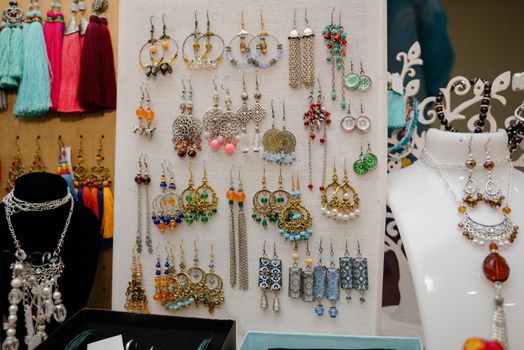 Shop window with necklaces and jewelry. Custome jewelry on display.Variety of colorful necklaces, bracelets, earrings, rings in window of costume jewelry store