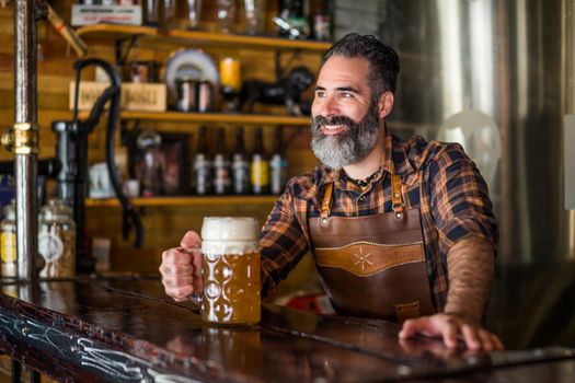 Portrait of barmen with beer glass full of beer at pub.