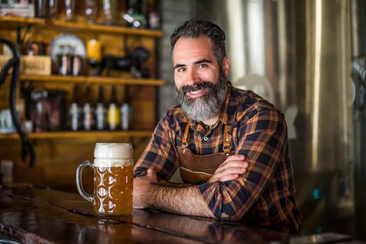 Portrait of barmen with beer glass full of beer at pub.