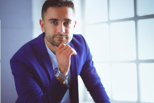 Young business man drinking a cup of coffee or tea.