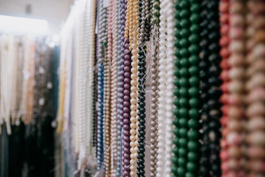 Shop window with necklaces and jewelry. Custome jewelry on display.Variety of colorful necklaces, bracelets, earrings, rings in window of costume jewelry store