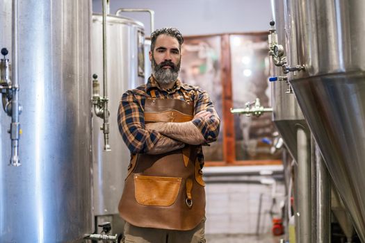 Portrait of man who is working at craft beer factory. Small family business, production of craft beer.